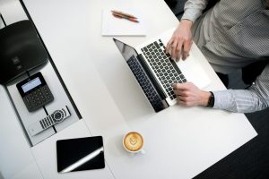 man's hand working on laptop